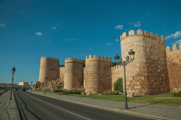 Street and light posts beside towers in the wall around Avila