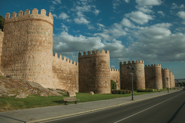 Street and light posts beside towers in the wall around Avila