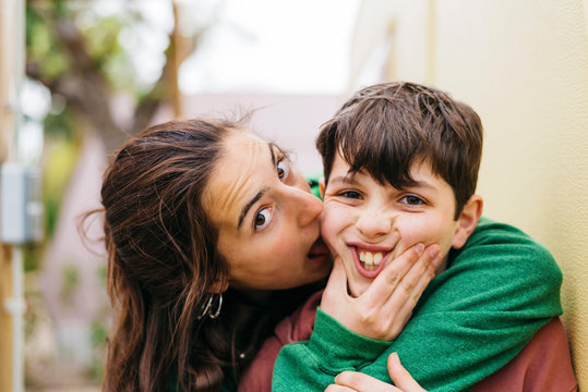Young woman licking her brother while looking camera outdoors
