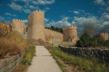 Fototapeta na wymiar Pathway and stone towers in the large wall of Avila