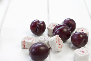 plums and Turkish Delight on a white wooden background
