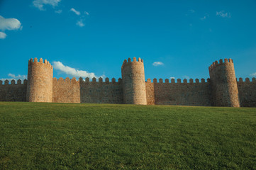 Fototapeta na wymiar Large wall with towers over hilly landscape encircling Avila