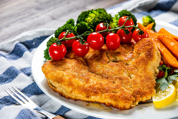 Fried pork chop, French fries and vegetable salad