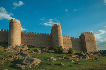 Fototapeta na wymiar Stone towers over rocky landscape encircling the town of Avila