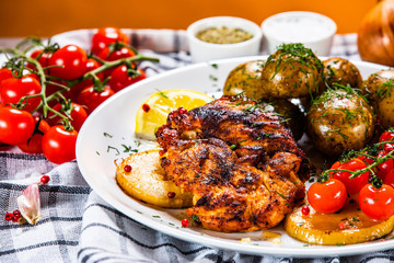 Grilled chicken fillet and vegetables on white plate