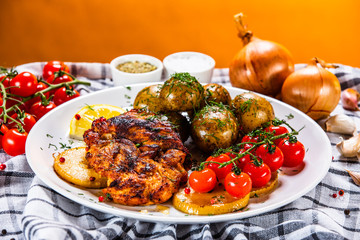 Grilled chicken fillet and vegetables on white plate