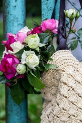 bouquet of fragrant English pink and white roses in a bag of raffia hanging on the fence