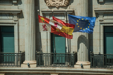 Flags fluttering in front of building facade at Avila