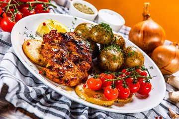 Grilled chicken fillet and vegetables on white plate