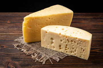Cheese on dark wooden background.