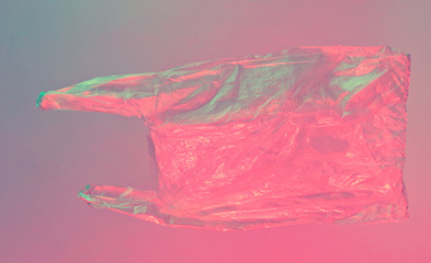 Minimalism pollution ecology concept. Crumpled plastic bag in neon red blue light