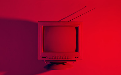 Retro wave, 80s. Old tv with antenna with red neon light. Top view, minimalism