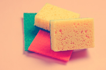Home and bathroom cleaning kit on pink background. Sponges, abrasives.