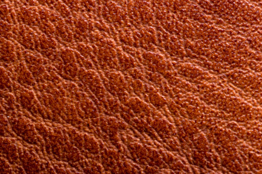 Leather background texture. Closeup of genuine red brown leather detail for design work. High resolution image or macro.