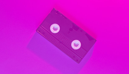 Retro wave style video cassette with neon pink toned. 80s. Top view