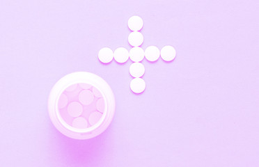 Bottle with pills, white pills in the shape of a cross on. Top view. Minimalism medical concept. Helping hand/ Tonned photo