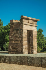 Fototapeta na wymiar The stone temple of Debod on a wooden garden in Madrid