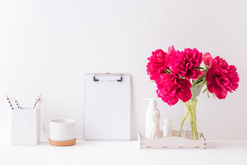 Home interior with decor elements. Mockup clipboard, red peonies in a vase, interior decoration