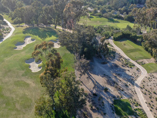 Aerial top view of a green golf course during sunny day. South California.