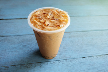 Pearl Bubble milk tea with ice in plastic cup on wooden floors