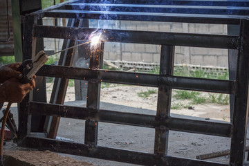 Welding Process with black block metal and bright sparks in steel