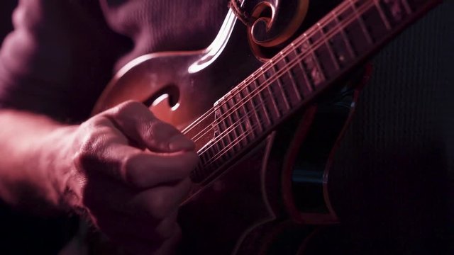 Folk musician playing mandolin, close up