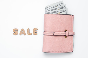 Trendy leather wallet with dollar bills on white background with word sale. Top view. Minimal concept