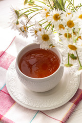 Still life with a cup of tea, cookies and daisies
