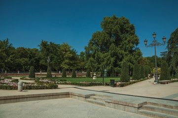 Obraz premium Pedestrian promenade with trees and streetlights in a park of Madrid