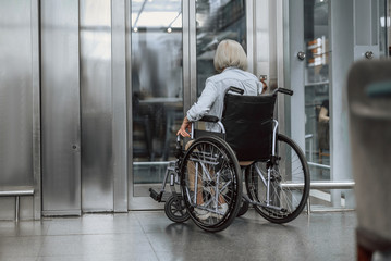 Adult woman on disabled carriage waiting for lift © Yakobchuk Olena