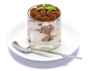 Classic tiramisu dessert in a glass on plate with spoon isolated on a white with clipping path