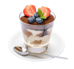 Classic tiramisu dessert with blueberries and strawberries in a glass isolated on a white background with clipping path