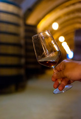 Tasting of fortified dry or sweet marsala wine in vintage wine cellar with old oak barrels in Marsala, Sicily, Italy