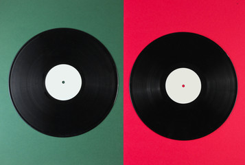 Two vinyl records on a green-red background. Retro style. Top view.