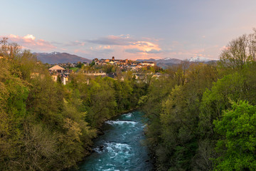 Oloron river and Oloron-Sainte-Marie city in sunset light. Mountains of French Atlantic Pyrenees are at background. © sasha64f
