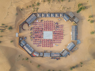 Aerial view of desert safari camp with straw roof huts, Al Awir, Dubai, UAE.