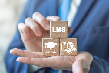 LMS Learning Management System concept on wooden blocks in man hands. Online business education. Electronic School.