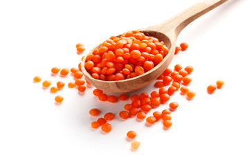Lentils in a wooden spoon isolated on white background