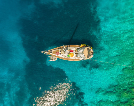 Aerial view of sailboat with inflatable mattresses anchored on coast, Ithaki, Greece.