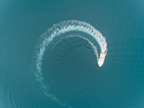 Aerial view of a boat driving in circle in the sea, Achaia, Greece.