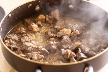 Roast meat in a frying pan. Roast meat in a black frying pan.