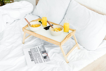 high angle view of table for breakfast on white bed in bedroom