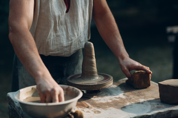 Fototapeta na wymiar Potter makes clay pot jar on potter's wheel