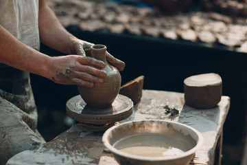 Potter makes clay pot jar on potter's wheel