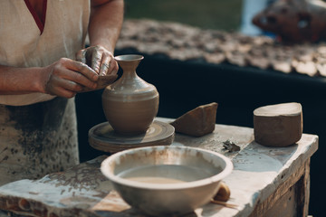 Potter makes clay pot jar on potter's wheel