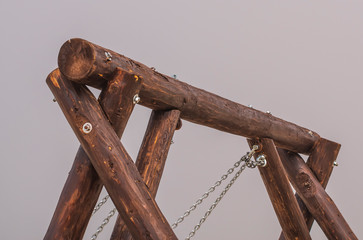 Top of a swing from logs on a background of fog