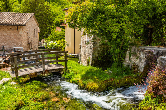 The small village of Rasiglia, crossed by many streams and waterfalls, fed by the Menotre river. A sluice regulates the flow of water. A wooden bridge. Old brick houses. Foligno, Umbria.