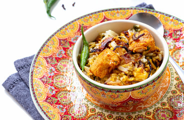 Halal Indian chicken Biryani served with yogurt tomato raita over white background. Selective focus.