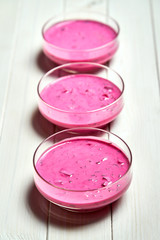 Three glass bowls with cold beetroot soup with dill on white table