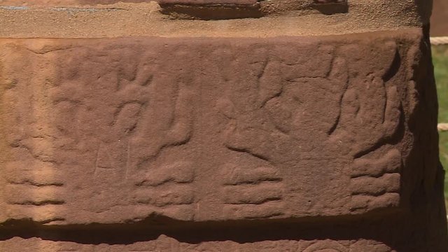 Extreme close-up low-angle panning shot of waist sandstone carving details on the ancient monolith at Tiwanaku, La Paz, Bolivia